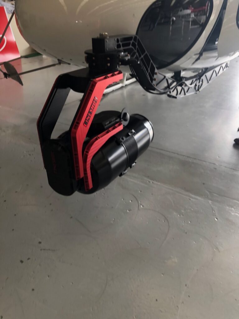 CineShot stabilization system mounted on commercial helicopter airframe rail